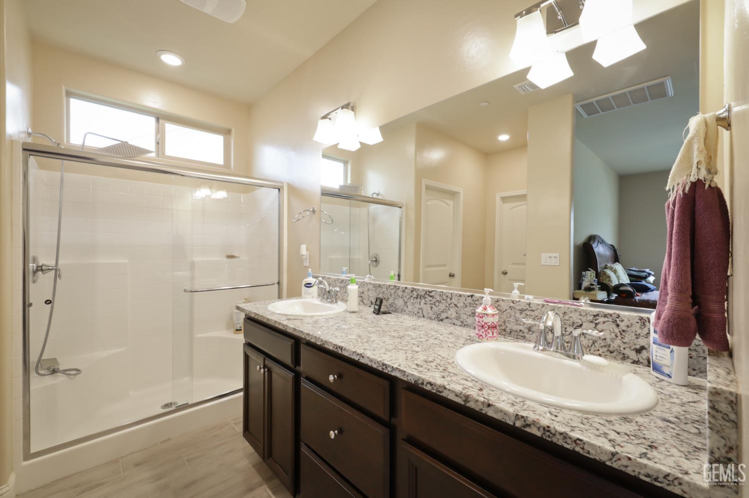 Undisclosed Address Shafter, CA 93263 - Photo 22 of 28 a bathroom with a granite countertop sink a large mirror and a shower