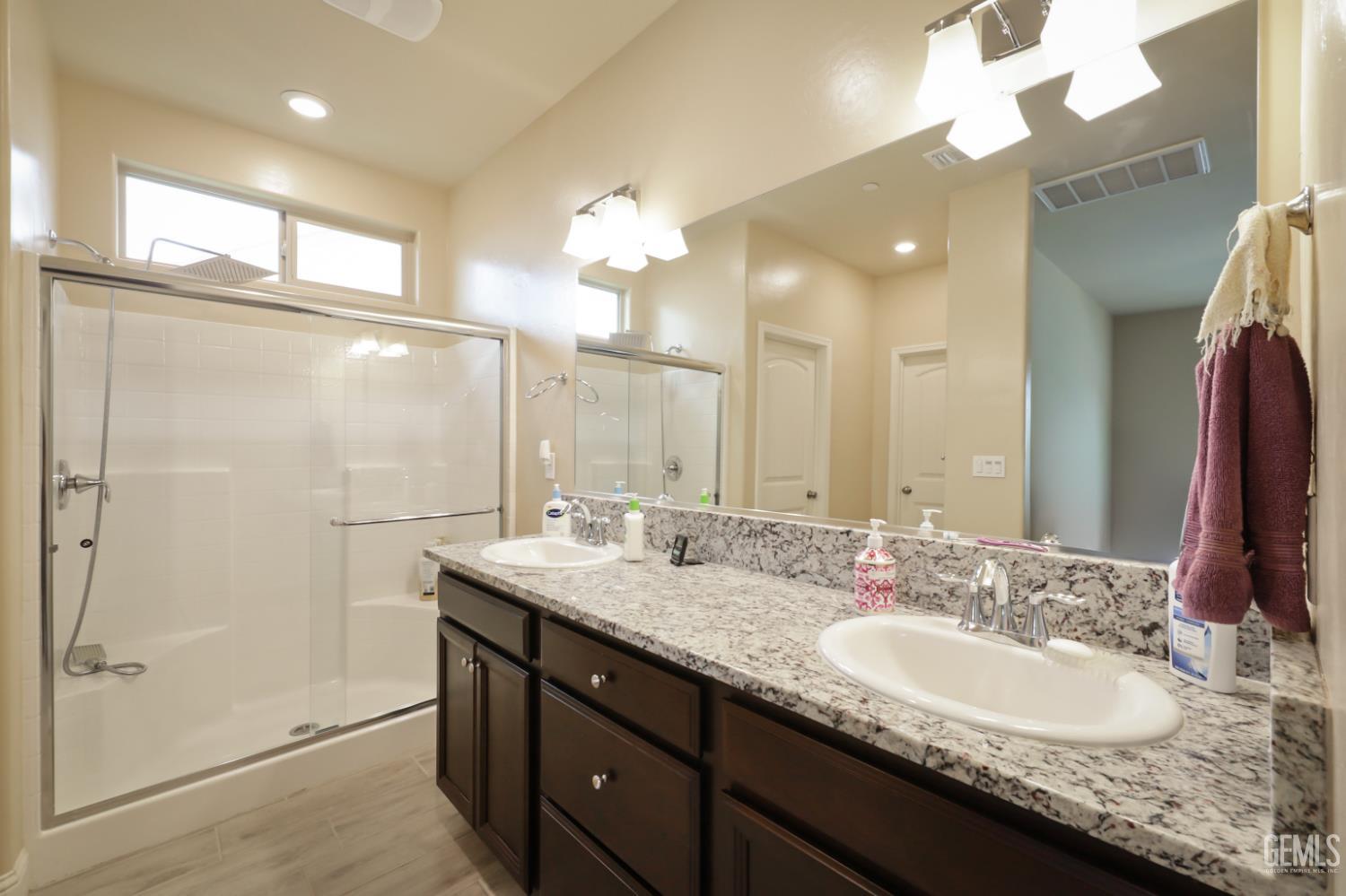 Undisclosed Address Shafter, CA 93263 - Photo 23 of 28 a bathroom with a granite countertop sink a large mirror and a shower
