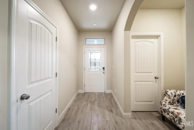 a view of a hallway with wooden floor and closet