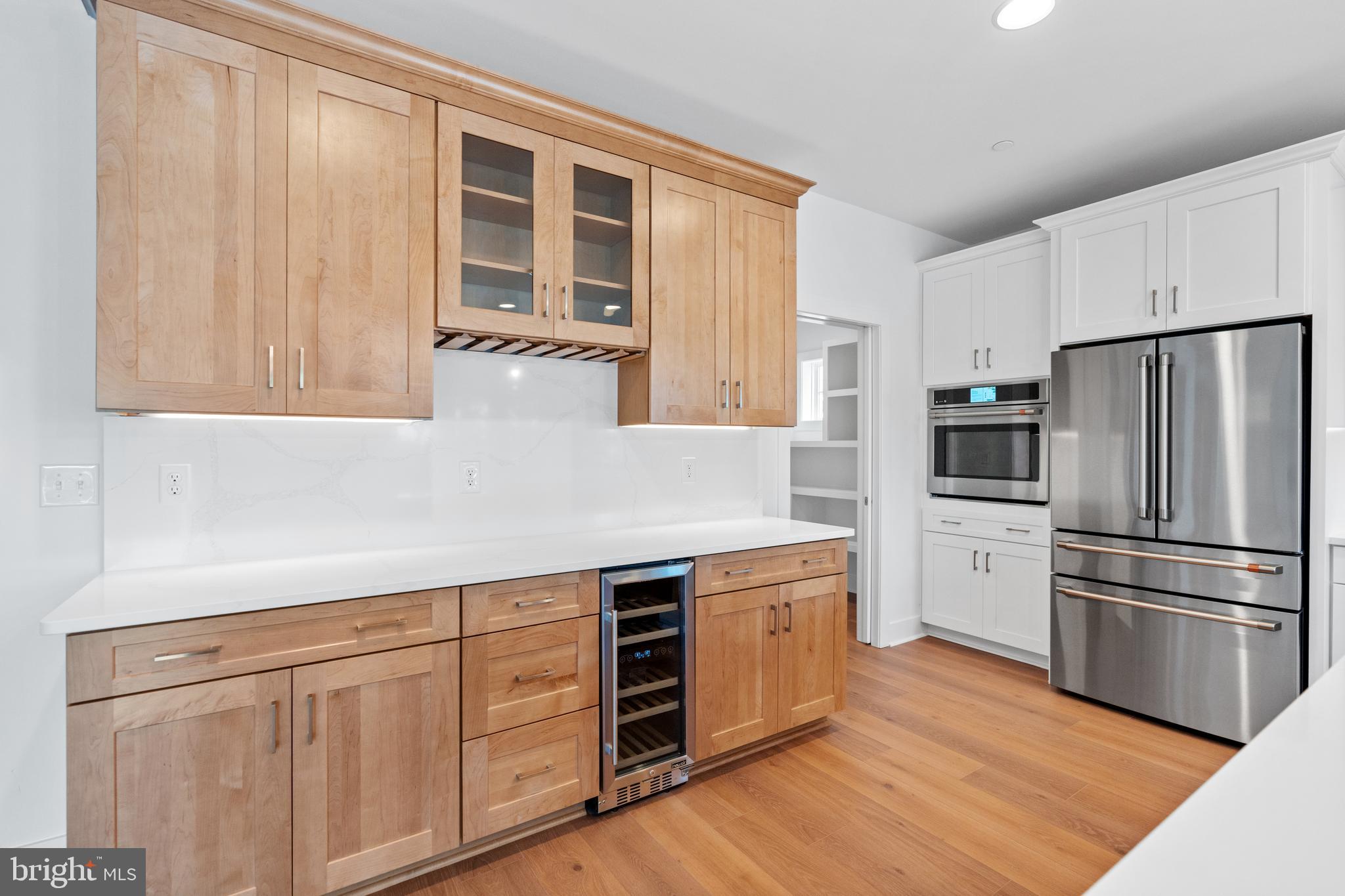22580 Hummingbird Road, Unit 17 Ellendale, DE 19941 - Photo 33 of 75 a kitchen with stainless steel appliances white cabinets and wooden floors