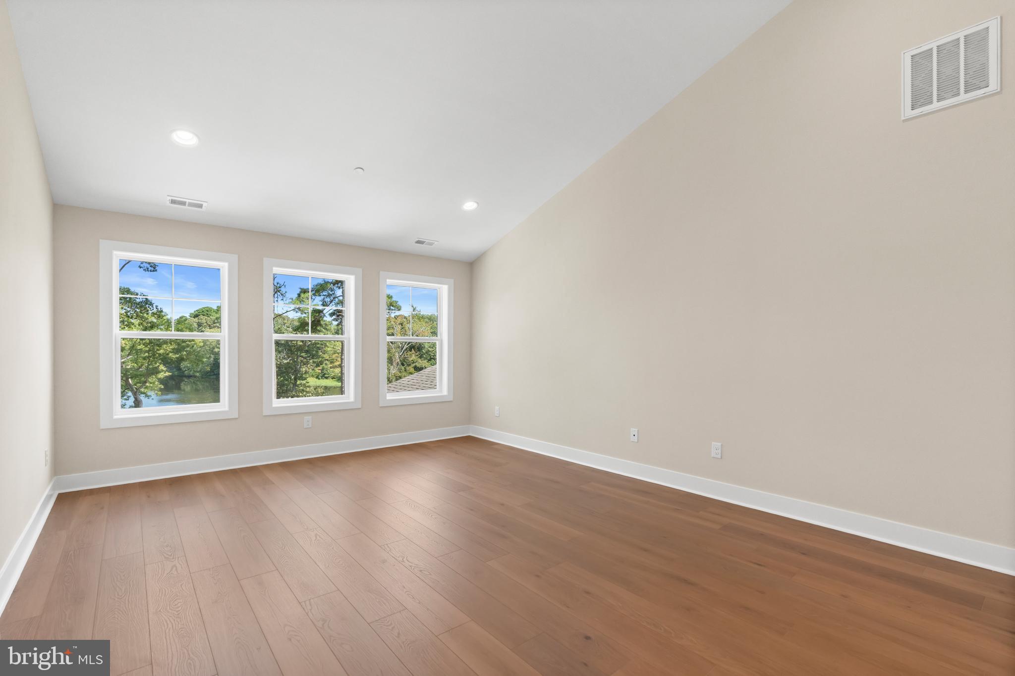 22580 Hummingbird Road, Unit 17 Ellendale, DE 19941 - Photo 37 of 75 an empty room with wooden floor and windows