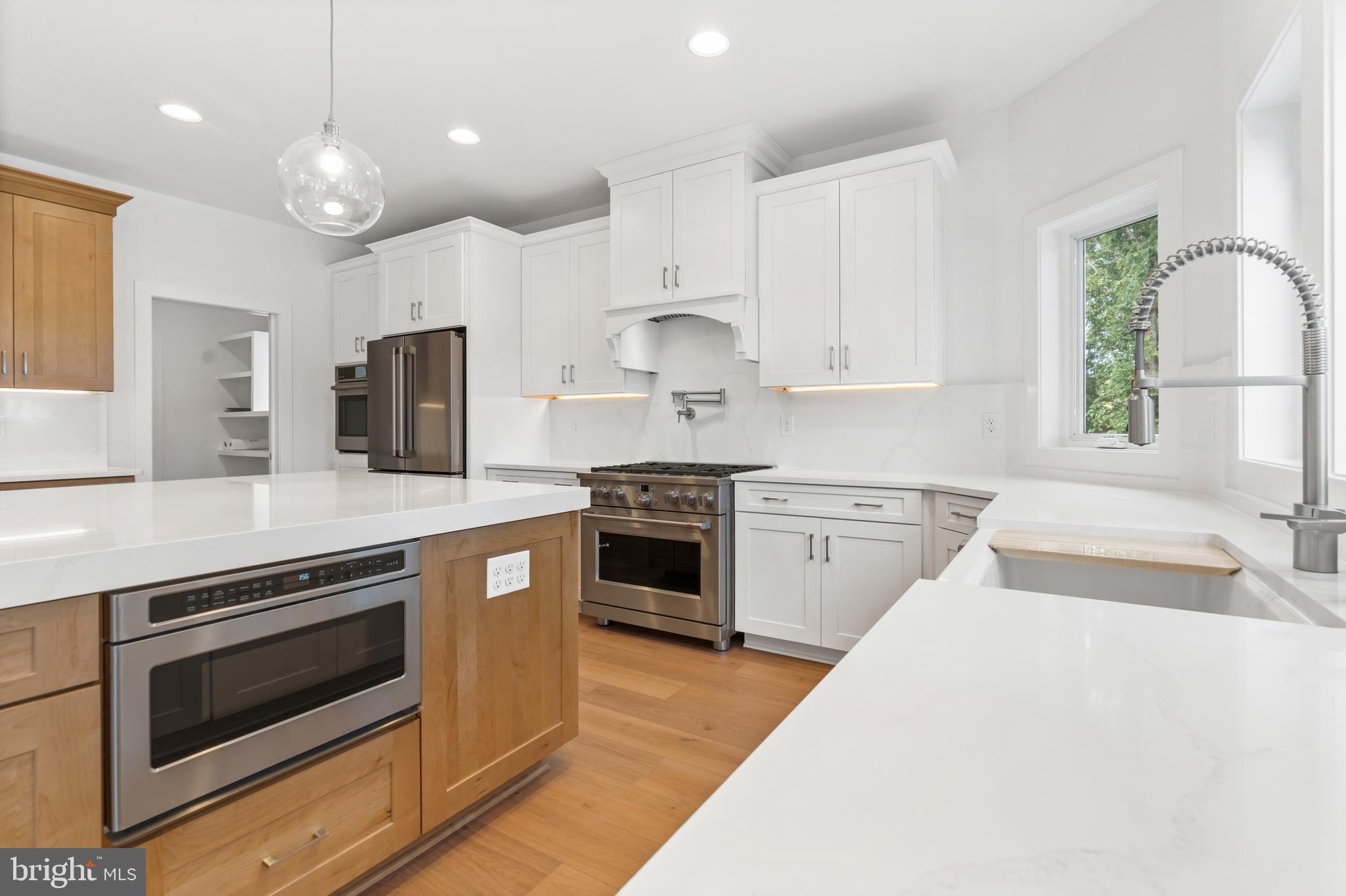 22580 Hummingbird Road, Unit 17 Ellendale, DE 19941 - Photo 55 of 75 a kitchen with stainless steel appliances granite countertop a stove top oven a sink dishwasher a refrigerator and a dining table with wooden floor