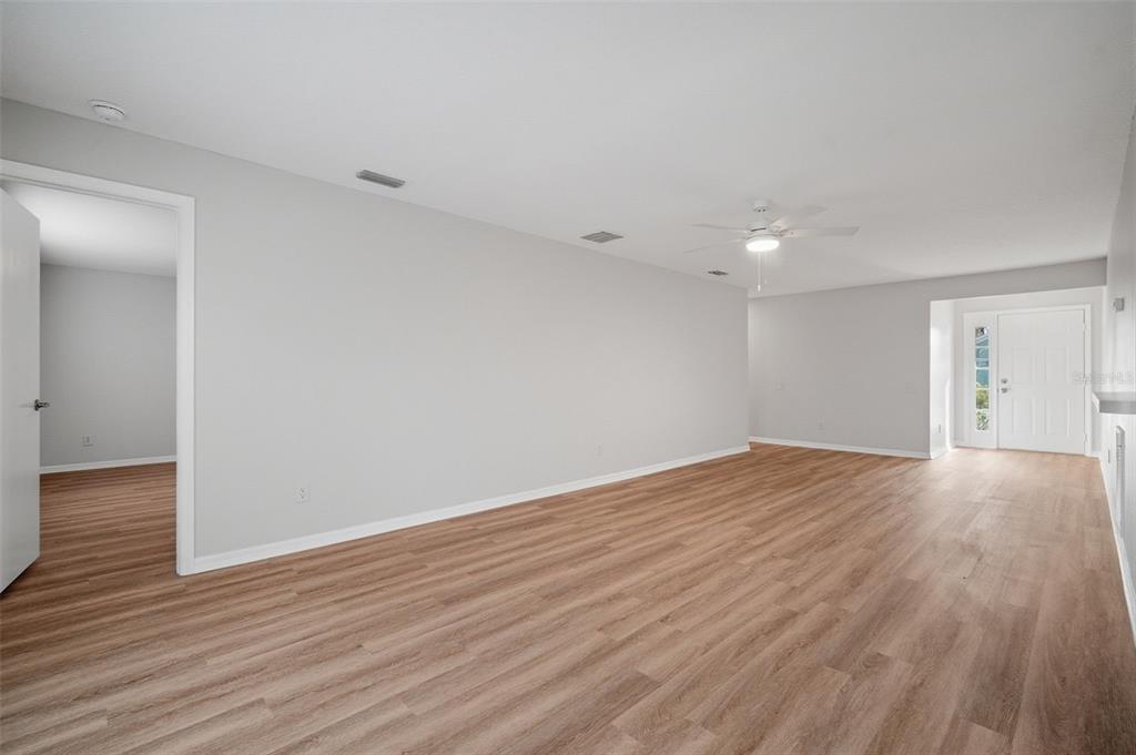 12407 Dawn Vista Drive Riverview, FL 33578 - Photo 21 of 44 a view of an empty room with wooden floor and a window