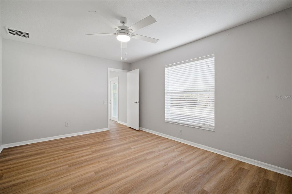 12407 Dawn Vista Drive Riverview, FL 33578 - Photo 24 of 44 a view of an empty room with wooden floor and a window