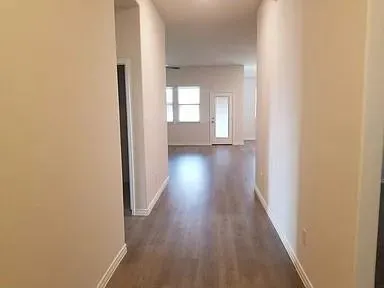 a view of a hallway with wooden floor