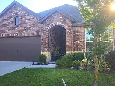 a front view of a house with a garden and plants