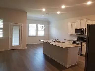 a kitchen with stainless steel appliances granite countertop a sink stove and refrigerator