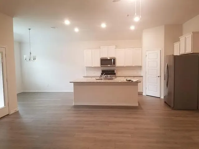 a kitchen with stainless steel appliances a refrigerator sink and white cabinets