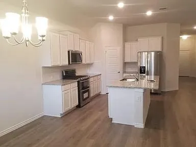 a kitchen with granite countertop white cabinets and stainless steel appliances