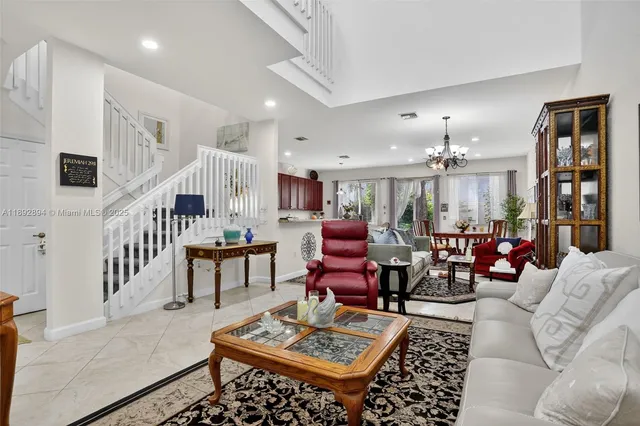 a living room with lots of furniture and view of kitchen