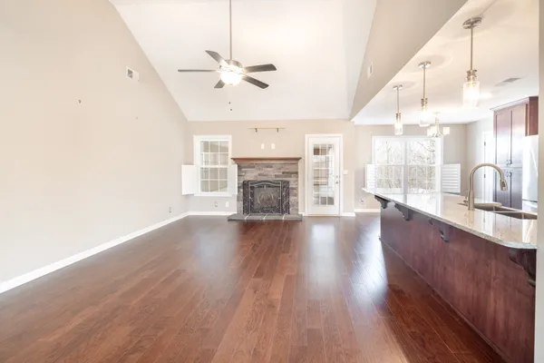 a view of an empty room with a fireplace and wooden floor