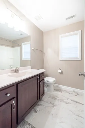 a spacious bathroom with a double vanity sink toilet and a mirror
