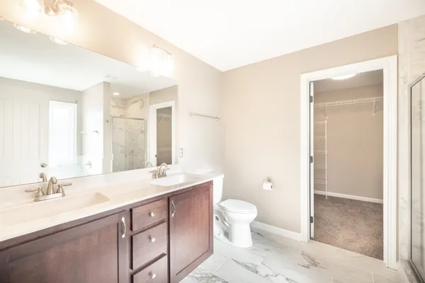 a bathroom with a granite countertop sink a toilet and a large mirror