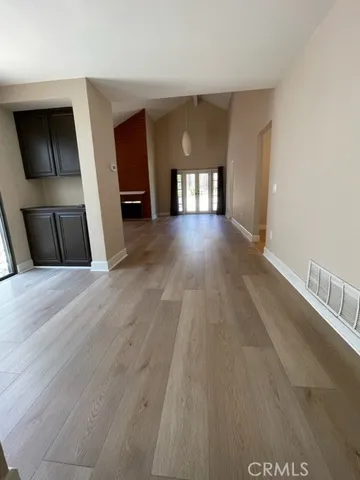 an empty room with wooden floor fireplace and windows