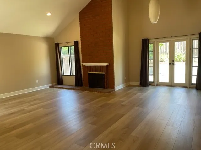 a large kitchen with stainless steel appliances granite countertop a stove a sink dishwasher and white cabinets with wooden floor