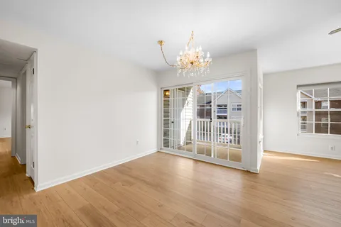 an empty room with wooden floor and large window