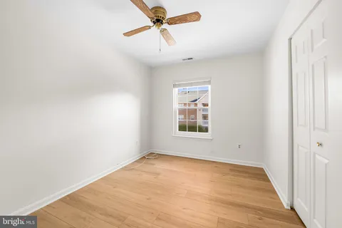 an empty room with a window and a ceiling fan
