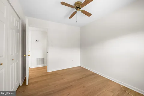 a view of a room with wooden floor and ceiling fan