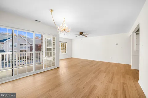 a view of a big room with wooden floor and windows