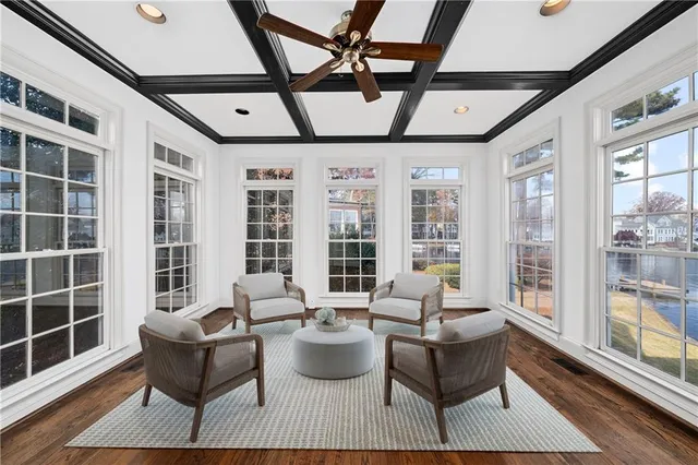 an empty room with wooden floor closet and windows
