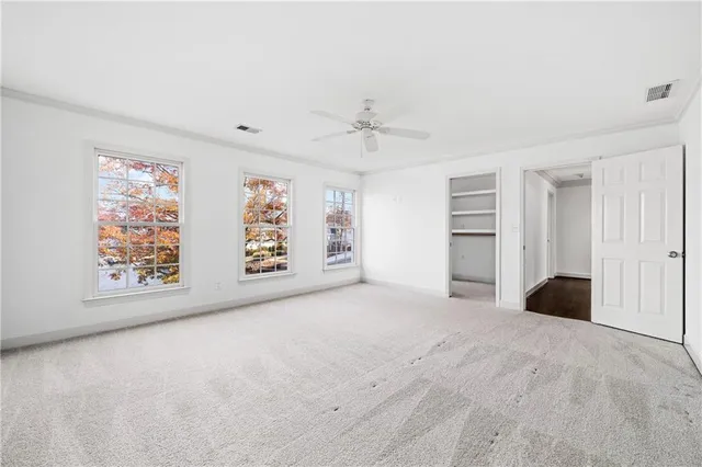 an empty room with windows and fan