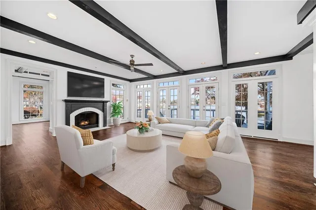 a living room with furniture a fireplace and a floor to ceiling window