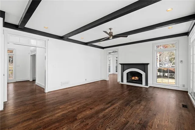 a view of empty room with wooden floor and fireplace