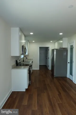 a kitchen with stainless steel appliances granite countertop a sink a stove a microwave a sink a refrigerator and cabinets