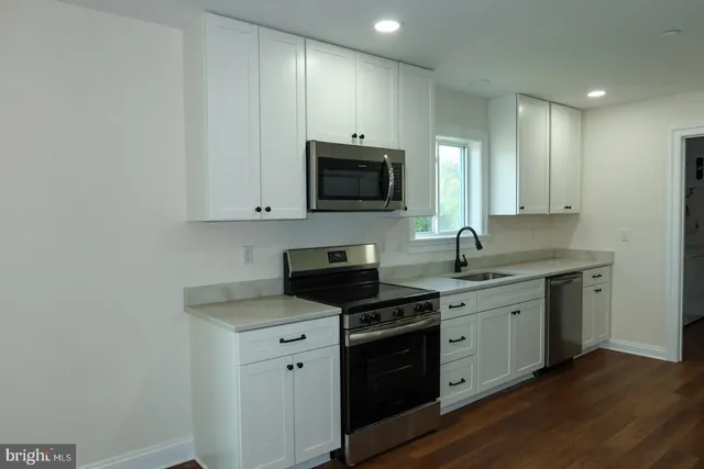 a kitchen with cabinets and wooden floor