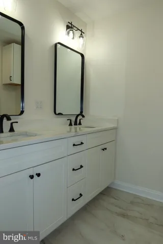 an empty room with wooden floor cabinet and windows