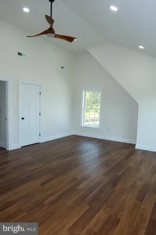 a view of a hallway with wooden floor and stairs