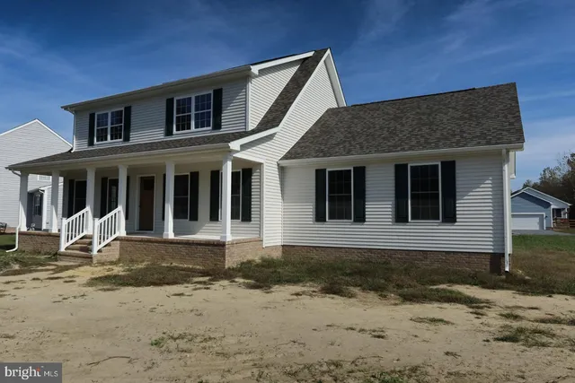 an empty room with wooden floor staircase and windows