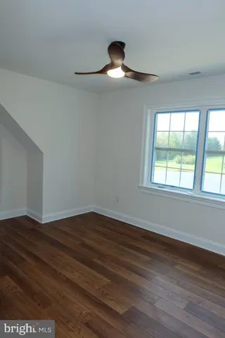a white toilet sitting next to a white wall