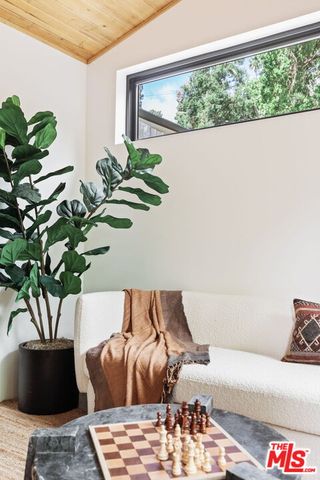 a living room with furniture floor to ceiling window and a flat screen tv
