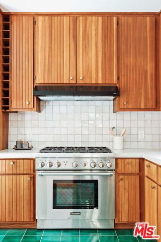 a kitchen with a window and a white wooden cabinets
