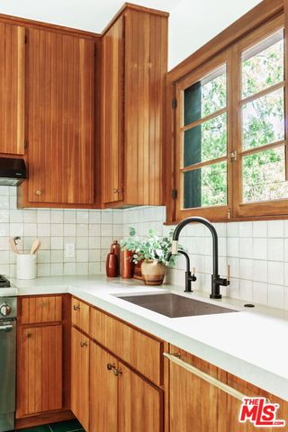 a bathroom with a sink a mirror a window and a bathtub