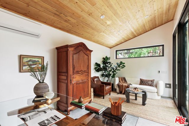 a living room with furniture flowerpot and wooden floor
