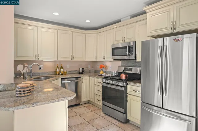 a kitchen with stainless steel appliances granite countertop a stove a refrigerator and a stove