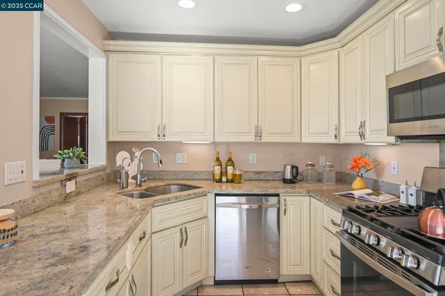 a kitchen with stainless steel appliances granite countertop a sink stove and cabinets