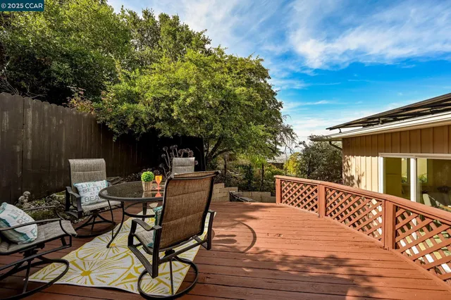 a view of a patio with table and chairs with wooden fence and floor