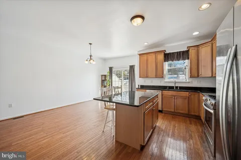 a kitchen with granite countertop a sink cabinets and wooden floor