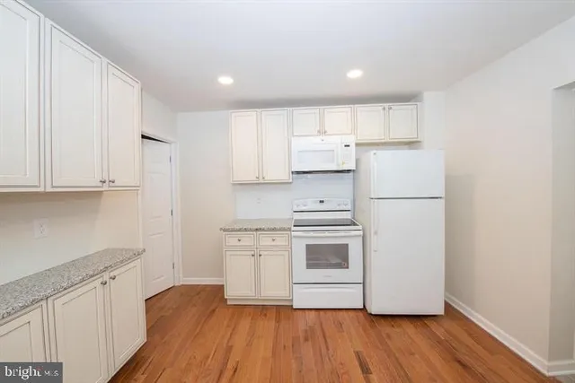 a kitchen with white cabinets and white appliances