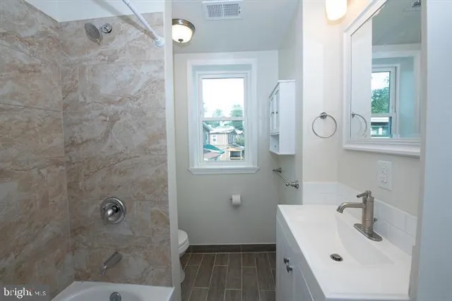 a bathroom with a sink a toilet and shower