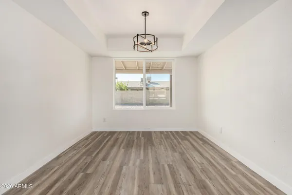a view of an empty room with wooden floor fireplace and a window