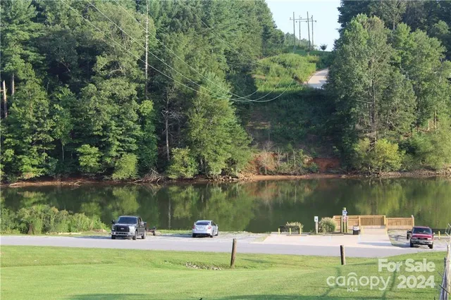 a view of a lake with a bench and trees