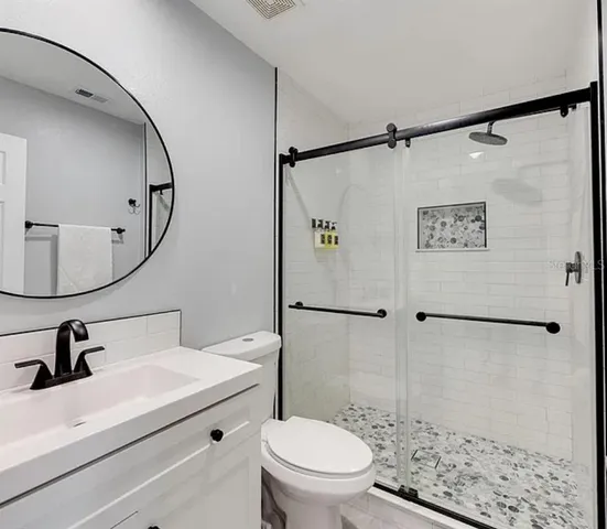 a bathroom with a sink a toilet and a shower