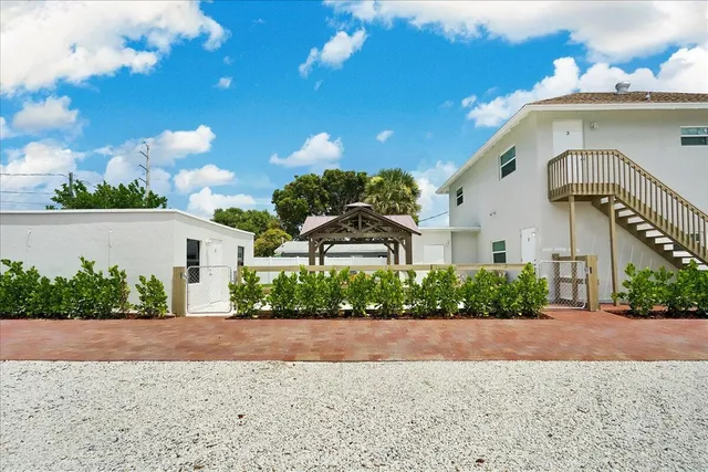 a front view of a house with a yard and potted plants