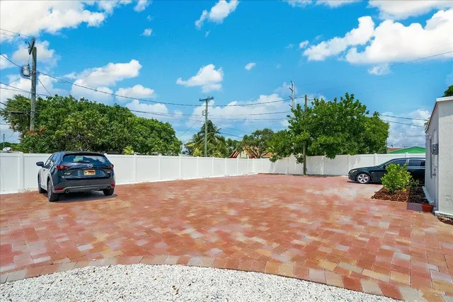 a view of a house with a yard and potted plants