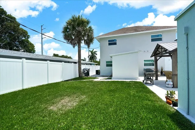 a view of a house with a big yard and a large tree