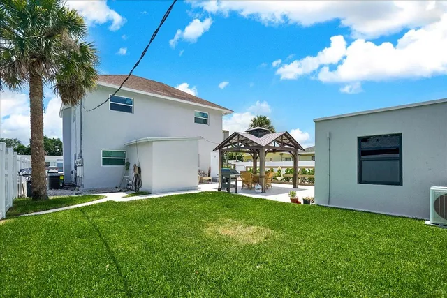 an aerial view of a house with garden space and lake view in back